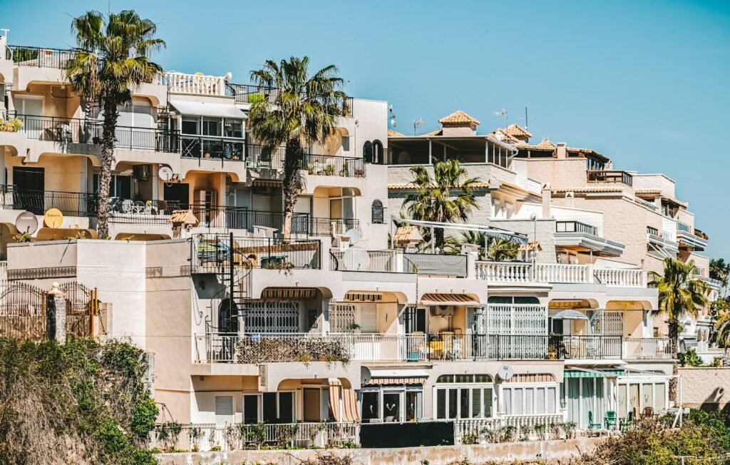 Edificio de apartamentos con terrazas y palmeras en la costa mediterránea