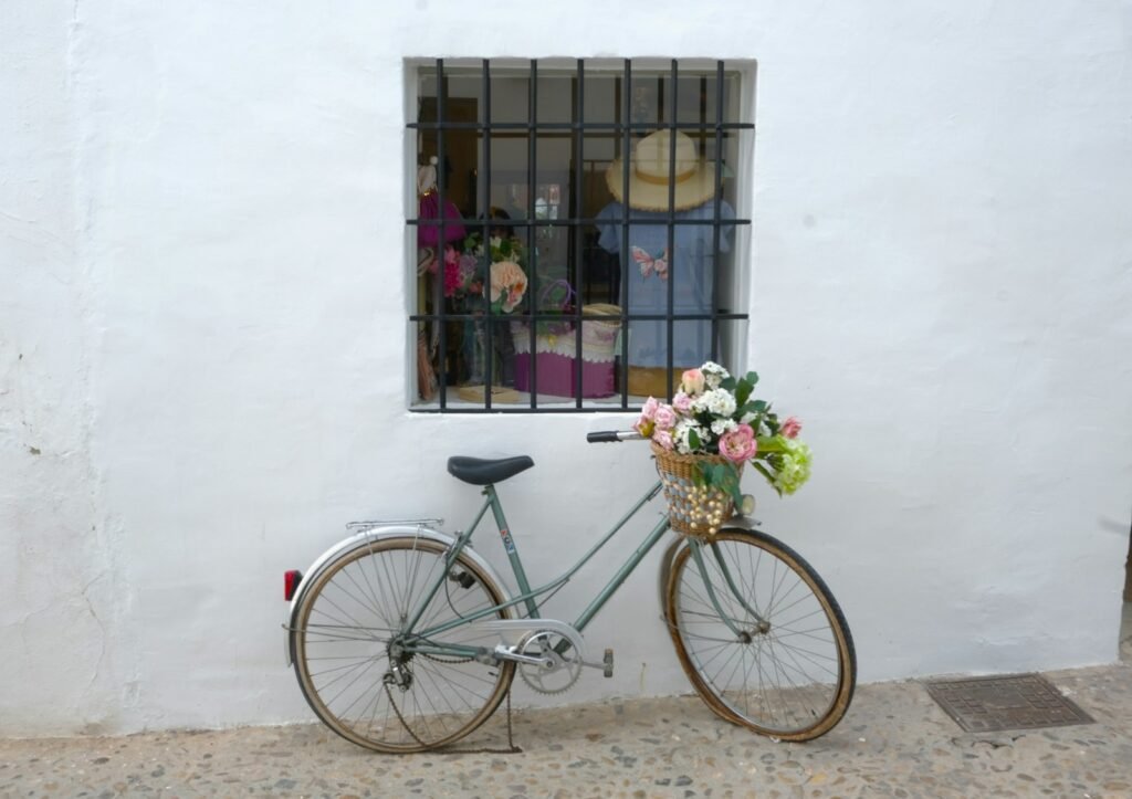 Bicicleta con flores en la cesta apoyada en una fachada blanca de Altea